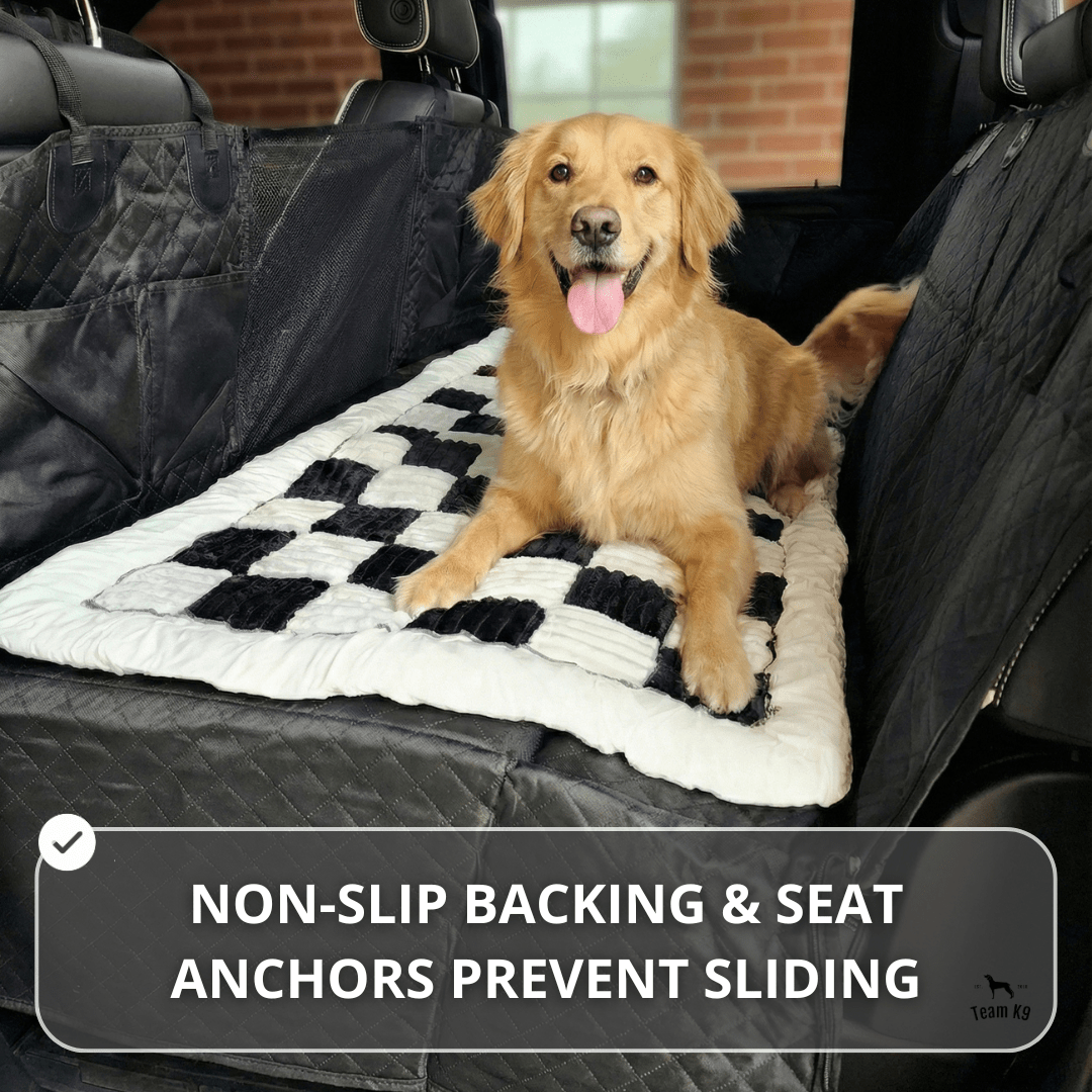 Dog sitting on a plush backseat bed layered over a Team K9 car seat cover