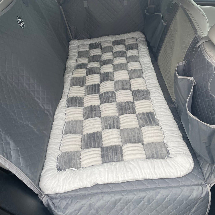 Gray Team K9 plush bed lying flat on a Gray hard bottom seat cover in a Lexus SUV