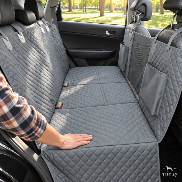 A hand smoothing the freshly installed hard bottom seat cover across a back seat