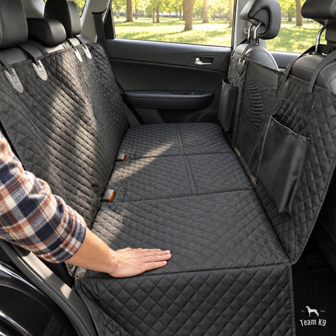A hand smoothing the black seat cover after install