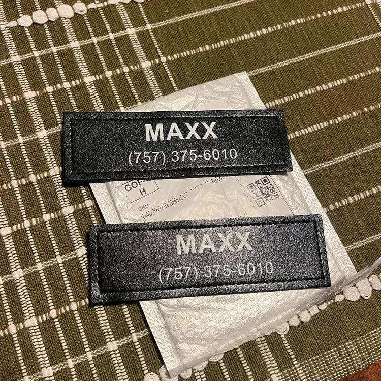 Two custom name patches reading MAXX with a phone number, fresh from the package
