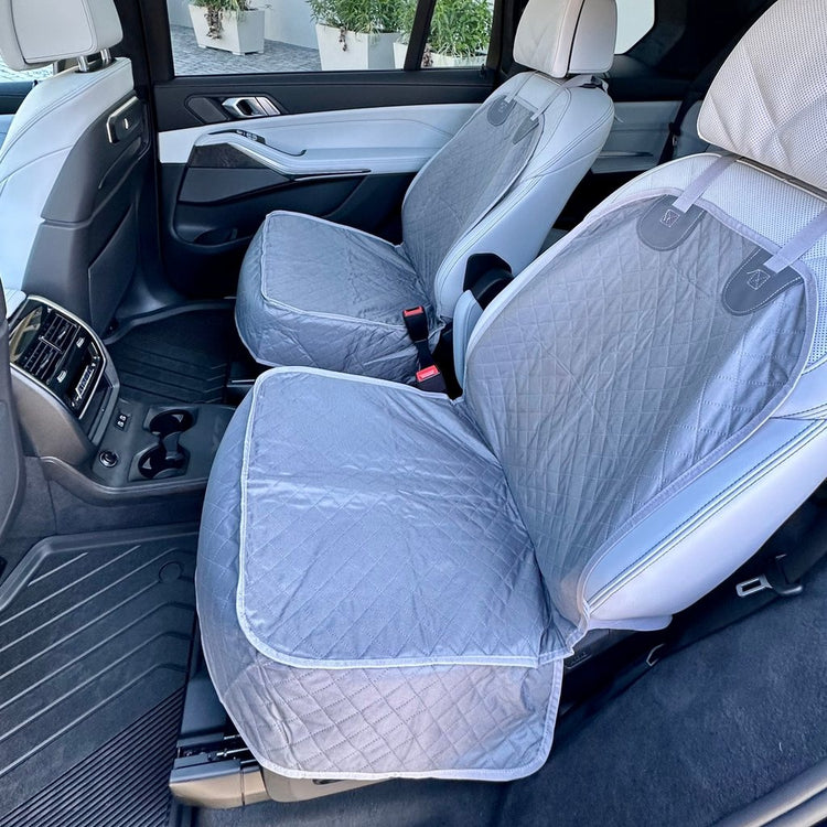 Two Gray Team K9 single-seat covers on the second-row captain's chairs of a BMW X7