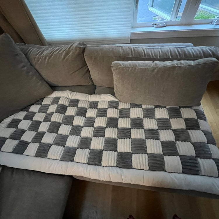 A customer's Gray Team K9 couch cover lying flat and clean on a sectional sofa